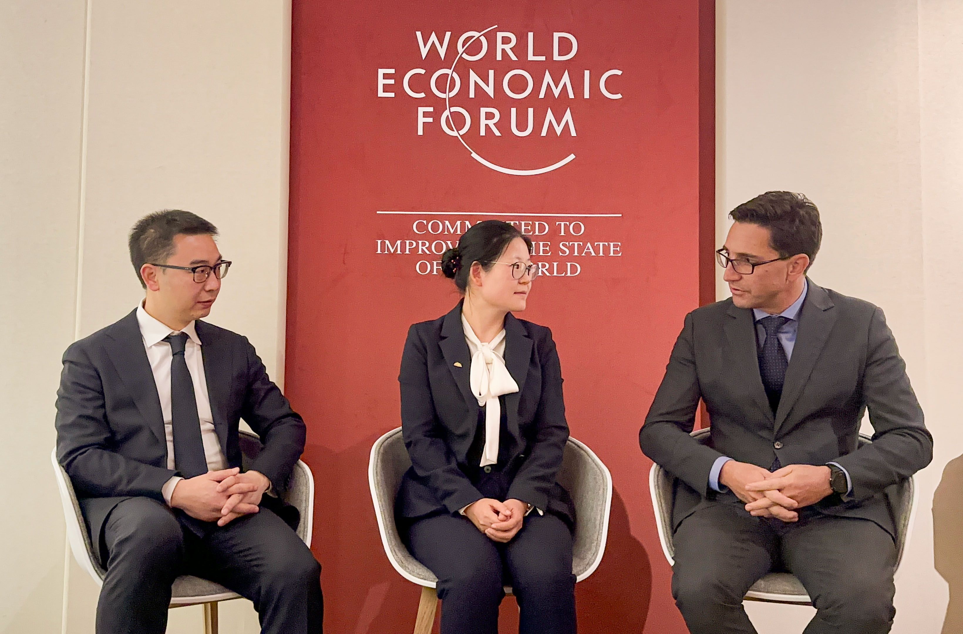 Dennis She (links), Vice President von LONGi, mit Xia Li (Mitte), Chief Executive Officer von Shenzhen Power Solution im World Economic Forum Congress Center